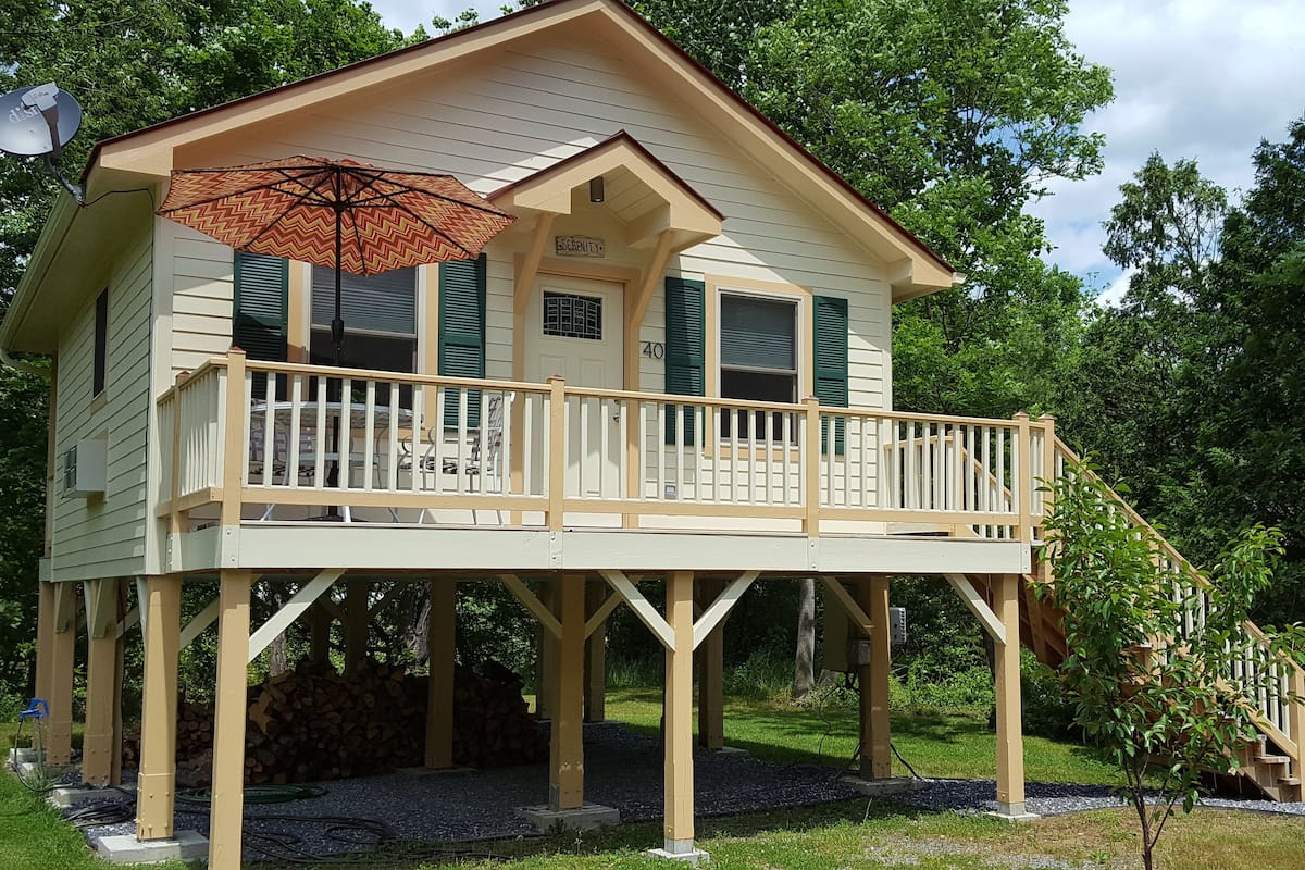 A two-story wooden house with a balcony and a deck.