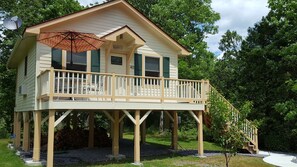 A two-story wooden house with a balcony and a deck.