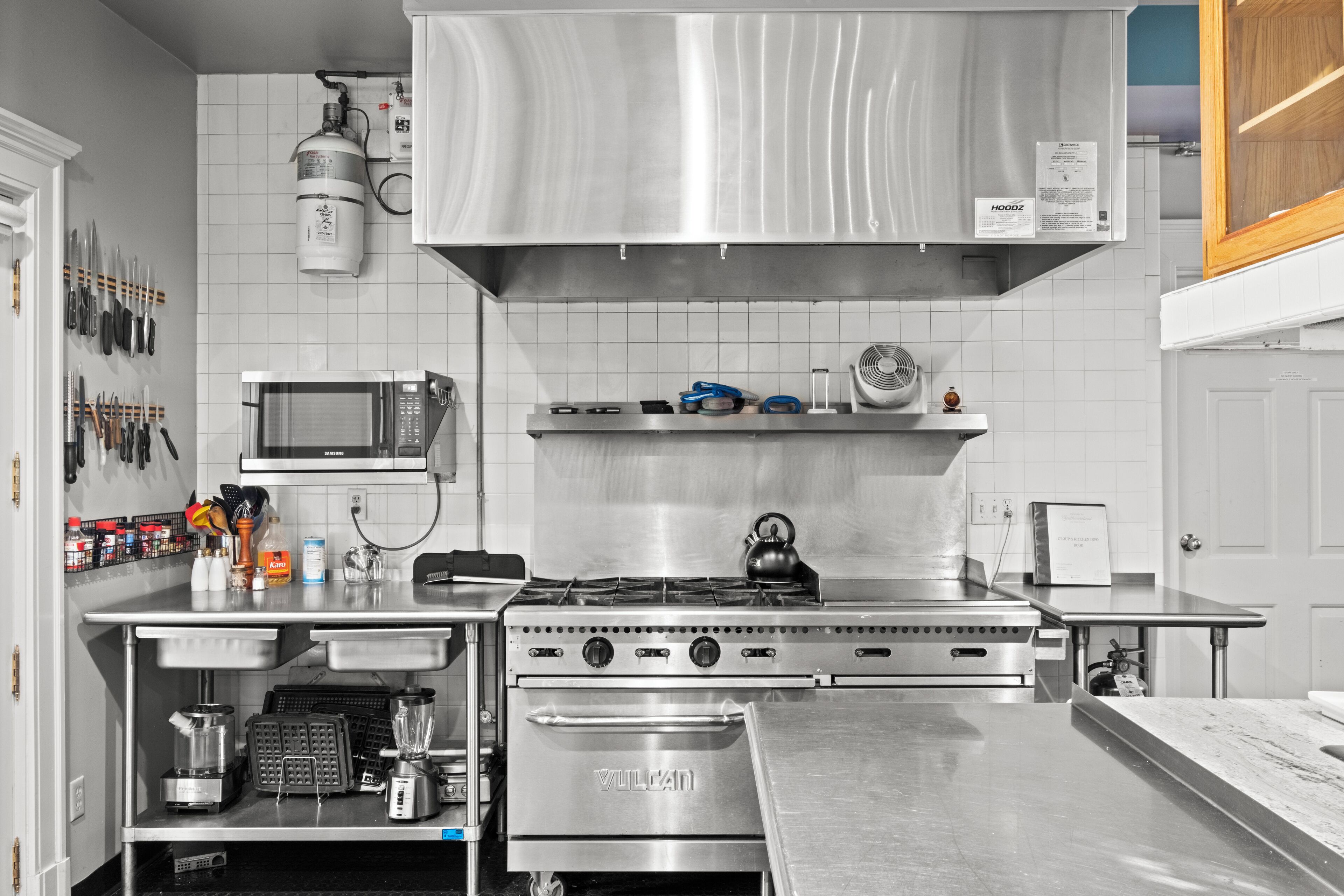 A kitchen with a stainless steel range hood, a microwave, and a gas stove.