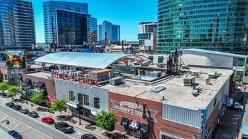 A downtown area with a mix of modern and older buildings, including a prominent red brick building with a sign for "John's Tavern."