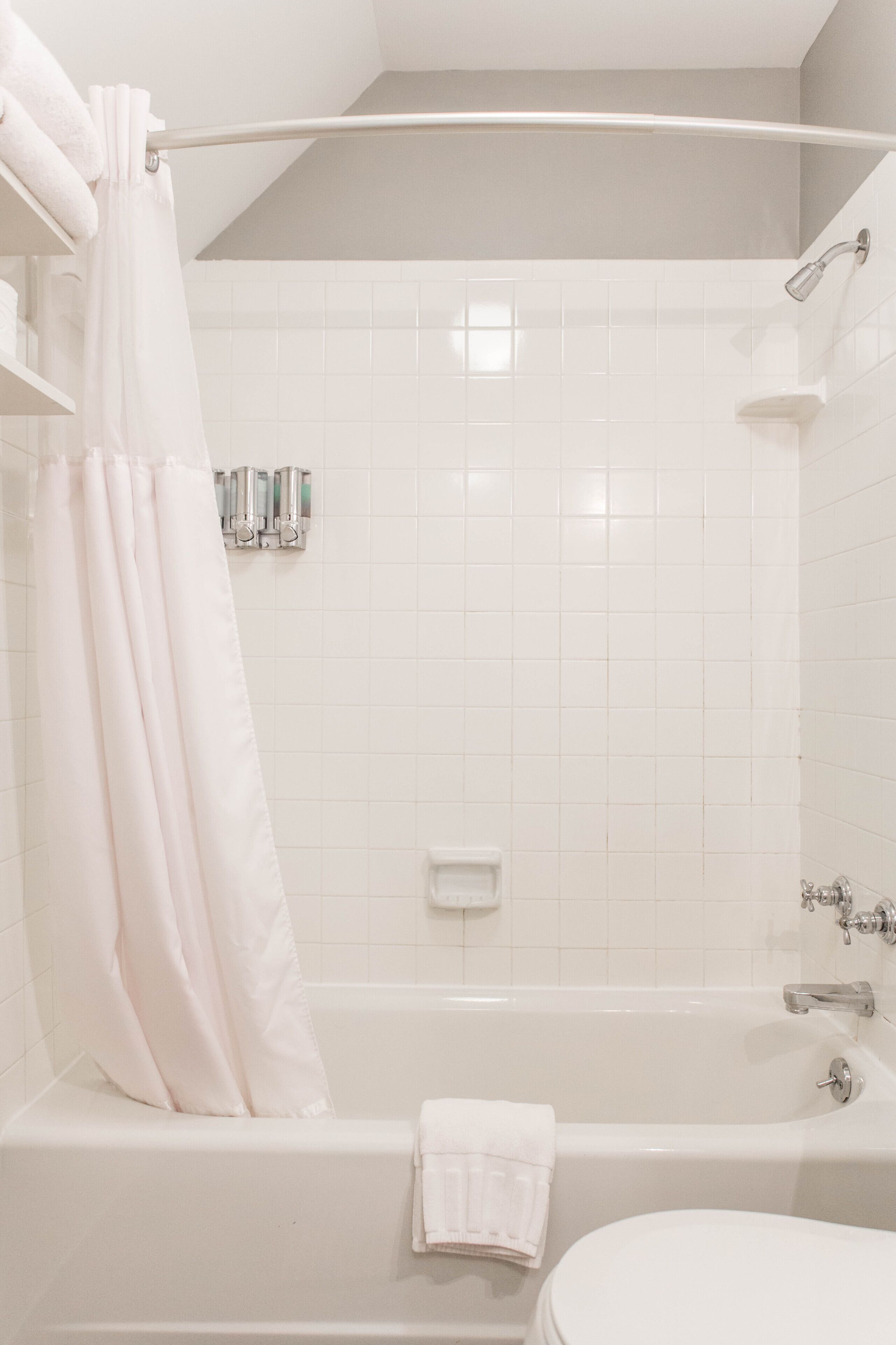 Un baño con bañera, inodoro y cortina de ducha.