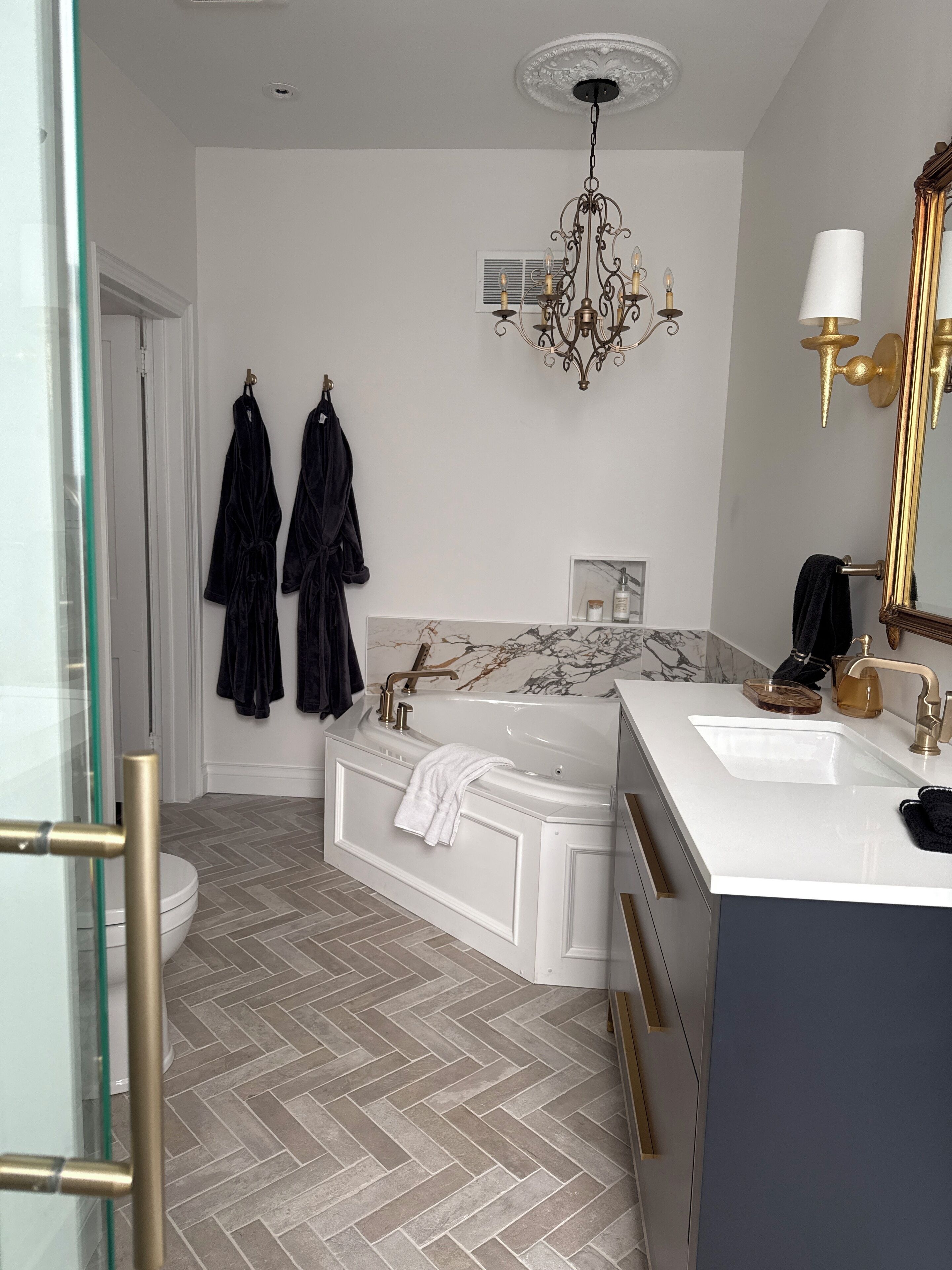 A modern bathroom with a freestanding bathtub, a double sink vanity, and a large mirror.