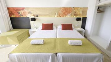 Een hotelkamer met twee bedden, een groot schilderij aan de muur en een nachtkastje met een lamp.
