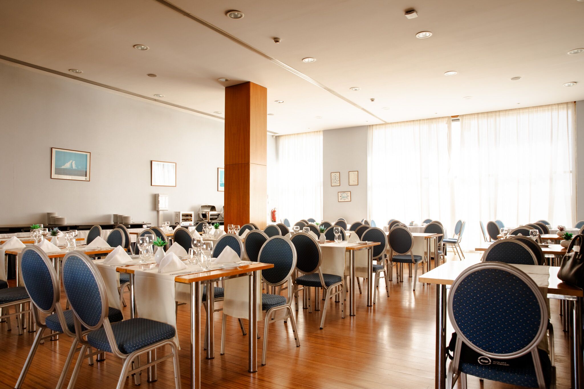 Un salón de conferencias con varias mesas y sillas, equipado con tarjetas de identificación y vasos.