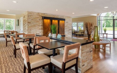 A modern dining area with a stone accent wall, multiple tables, and chairs.