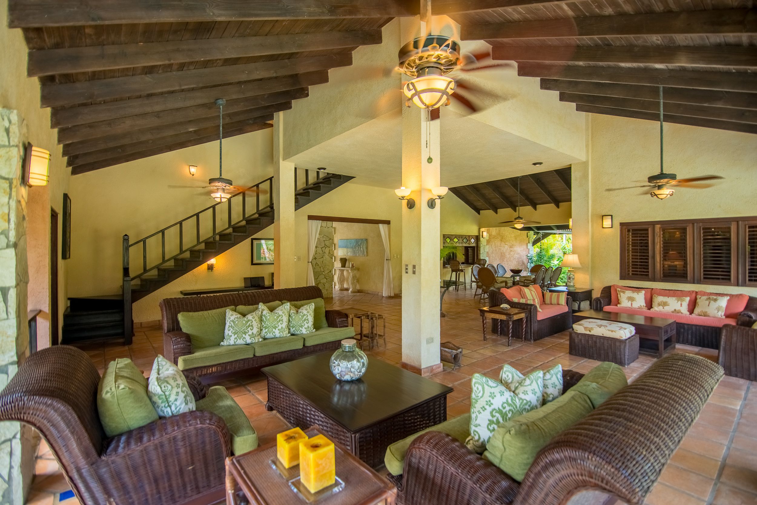 A spacious living area with a high ceiling, a staircase, and a dining area.