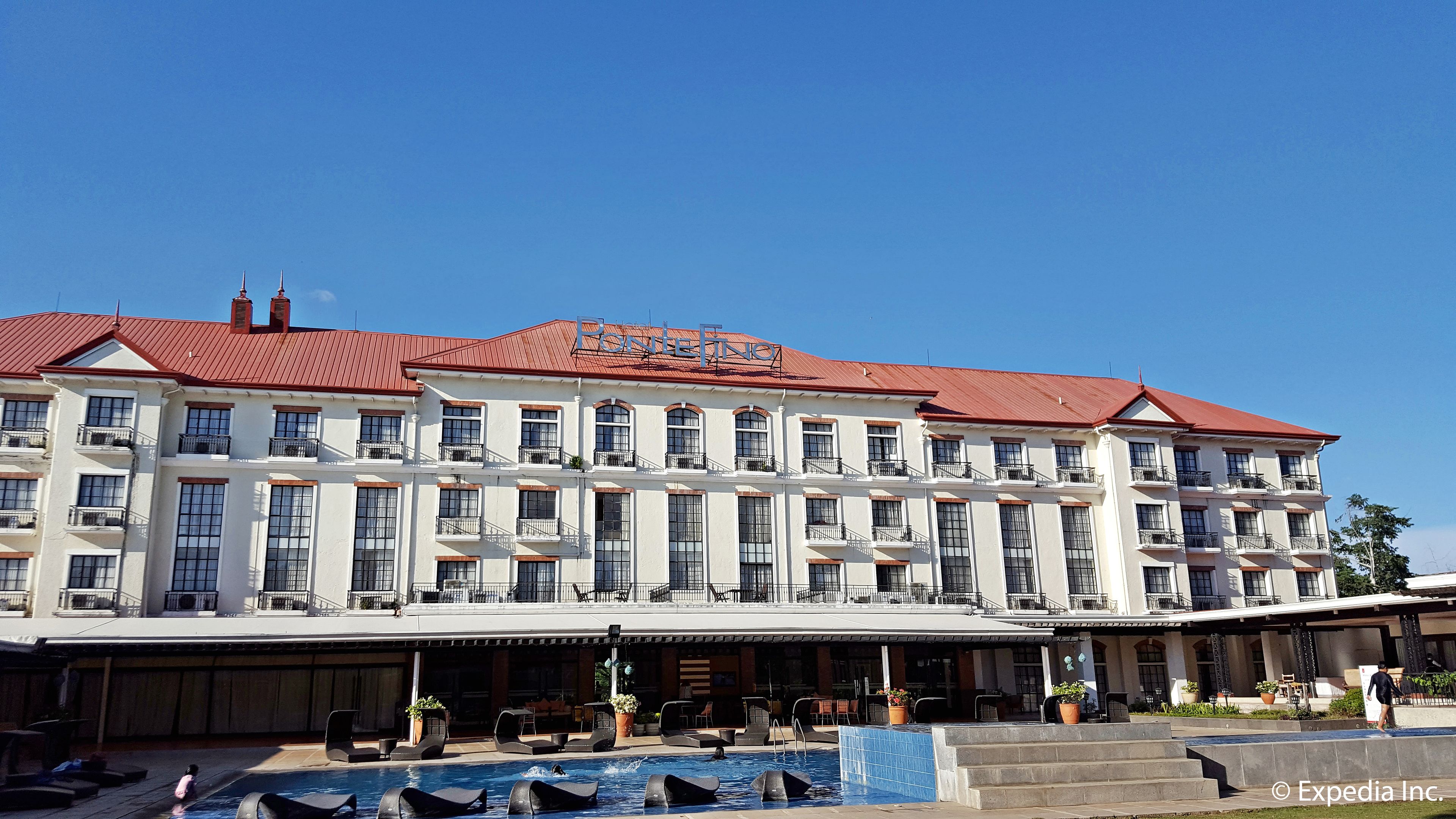 Ein großes Hotel mit rotem Dach und mehreren Balkonen.