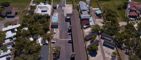 Vista aérea de um bairro residencial com casas, piscina e rua.