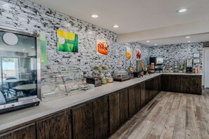 A breakfast bar with a marble backsplash, a coffee machine, and various breakfast items. - Quality Inn Rockport on Aransas Bay (Rockport)