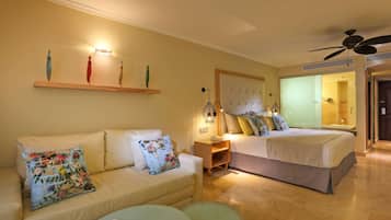 Una habitación de hotel con sofá, cama, mesita y mesita de noche.