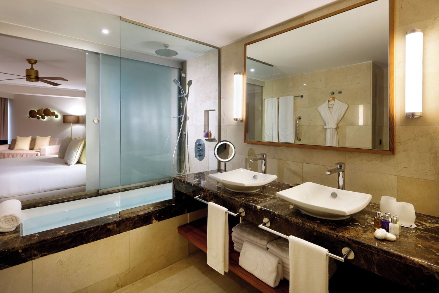 A modern bathroom with two sinks, a glass shower enclosure, and a large mirror.