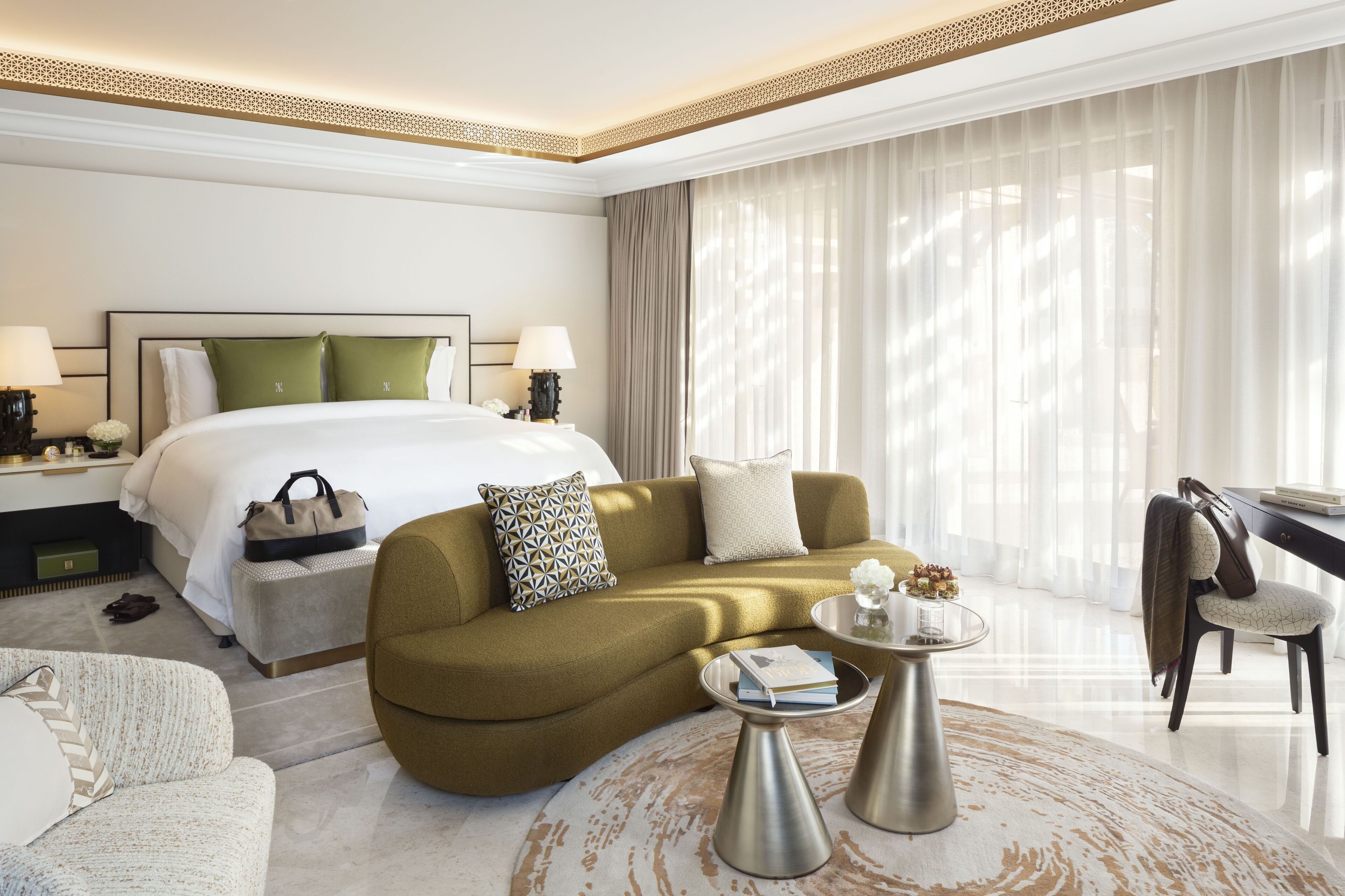 Una habitación de hotel moderna con una cama grande, un sofá, una mesita de café y un escritorio.
