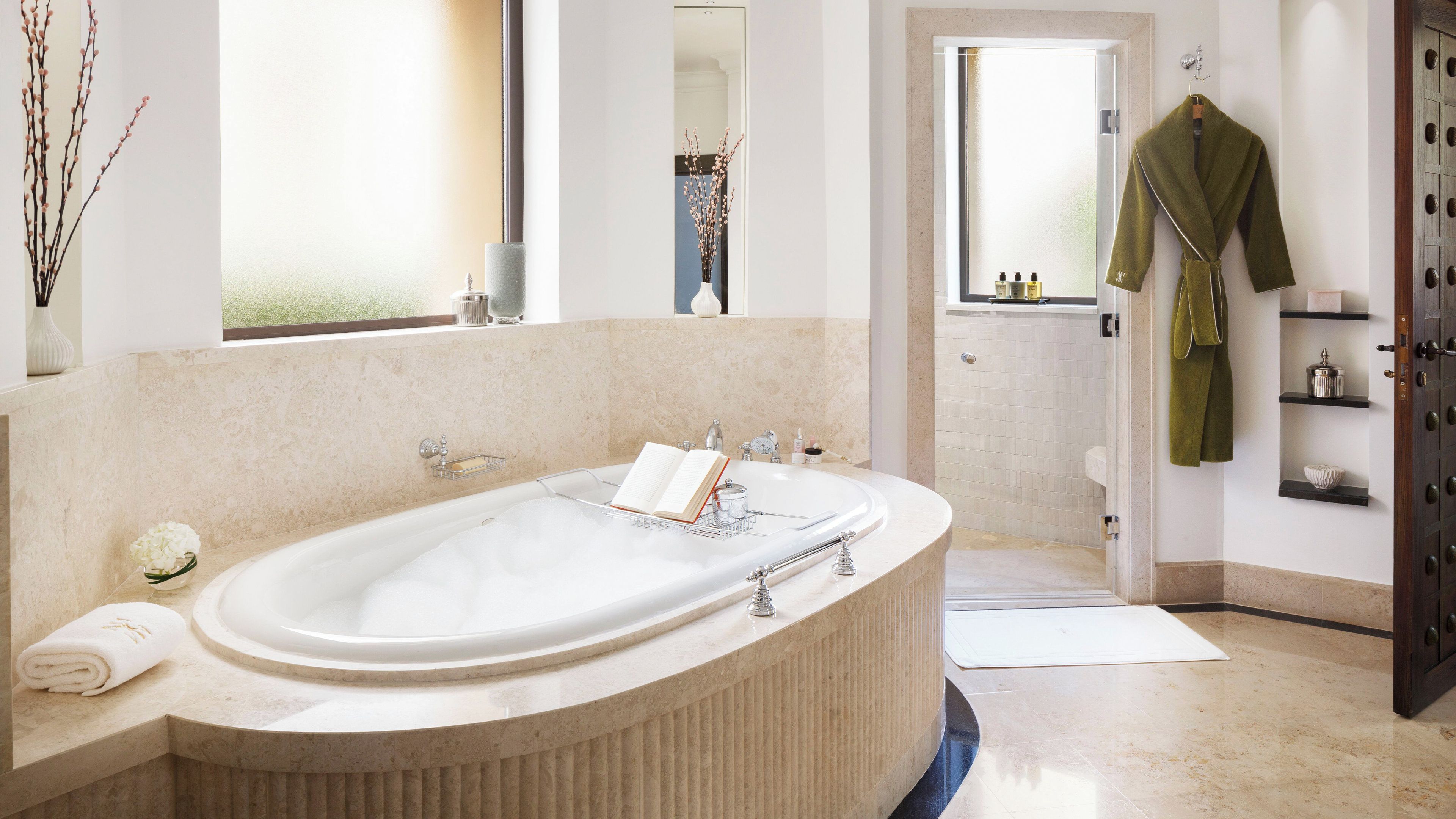 A modern bathroom with a freestanding bathtub, a vanity with a mirror, and a shower area.