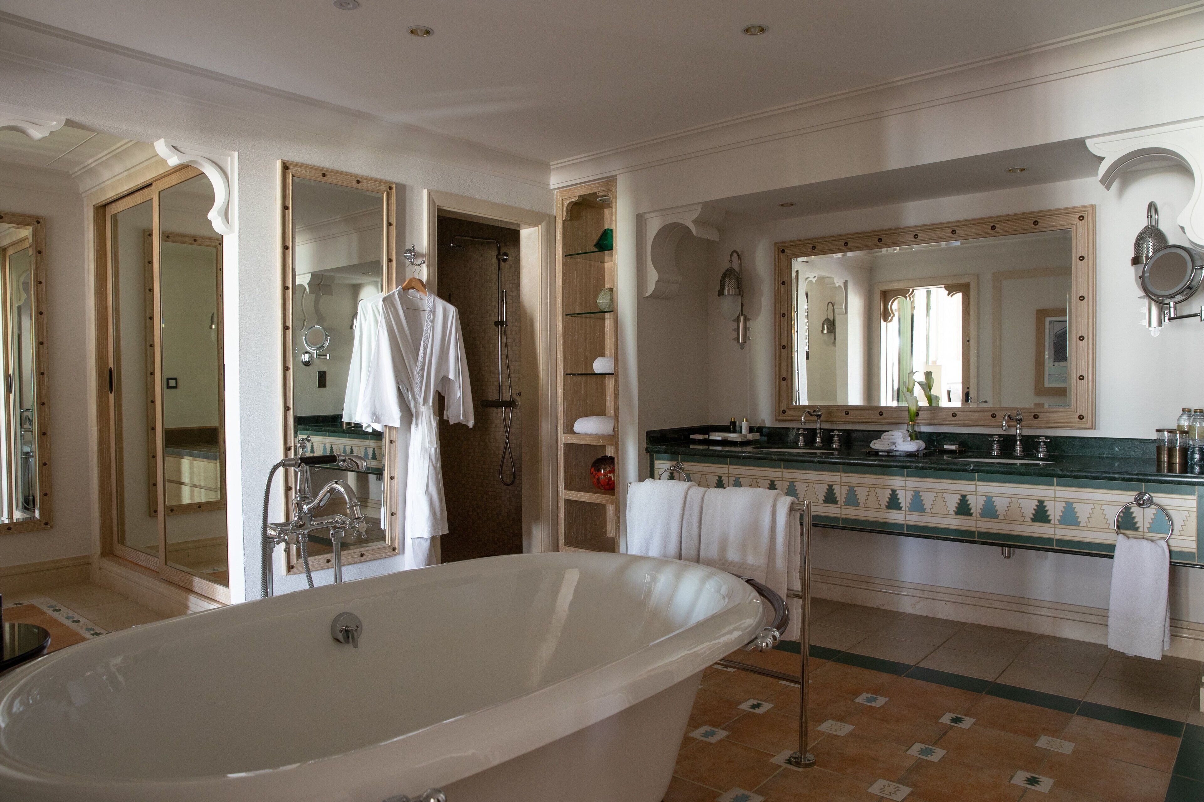 Un baño espacioso con una bañera grande, una ducha a ras de suelo y un tocador con espejo.