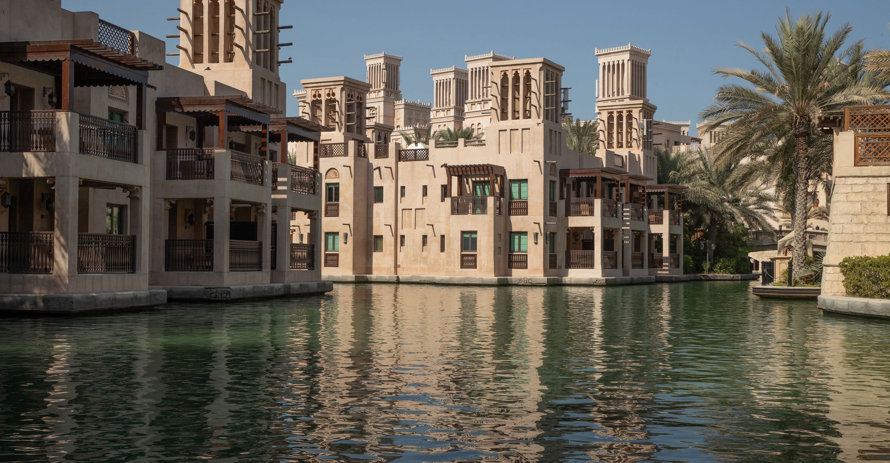 Un canal bordé d’édifices à l’architecture traditionnelle, avec de nombreux balcons, et dont les eaux reflètent les bâtiments.
