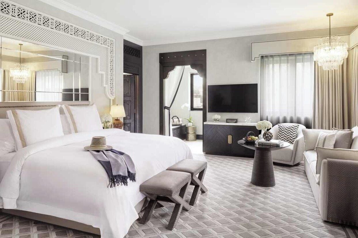 Une chambre d’hôtel avec un grand lit, un canapé, une télévision et une table à manger.