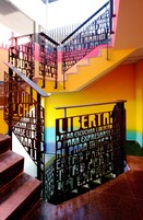 Eine mehrstufige Treppe mit Metallgeländern und einer farbenfrohen Wand.