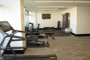 A gym with exercise equipment including treadmills, stationary bikes, and weights.