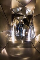 A geometric, metallic interior with reflective surfaces and a central pathway.