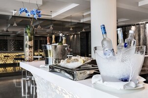 Eine Bar mit einer weißen Theke, Eiseimern, Flaschen und einer Platte Austern.