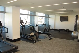 Ein Fitnessstudio mit Laufbändern, Crosstrainern und Übungsbällen.