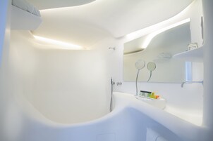 Ein modernes Badezimmer mit freistehender Badewanne, einem großen Spiegel und einem minimalistischen Design.