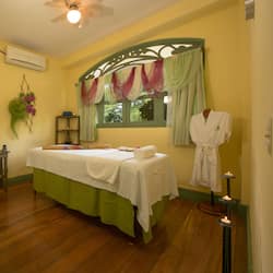 Relax in a serene spa room with a plush bed, candles, and a beautiful view.