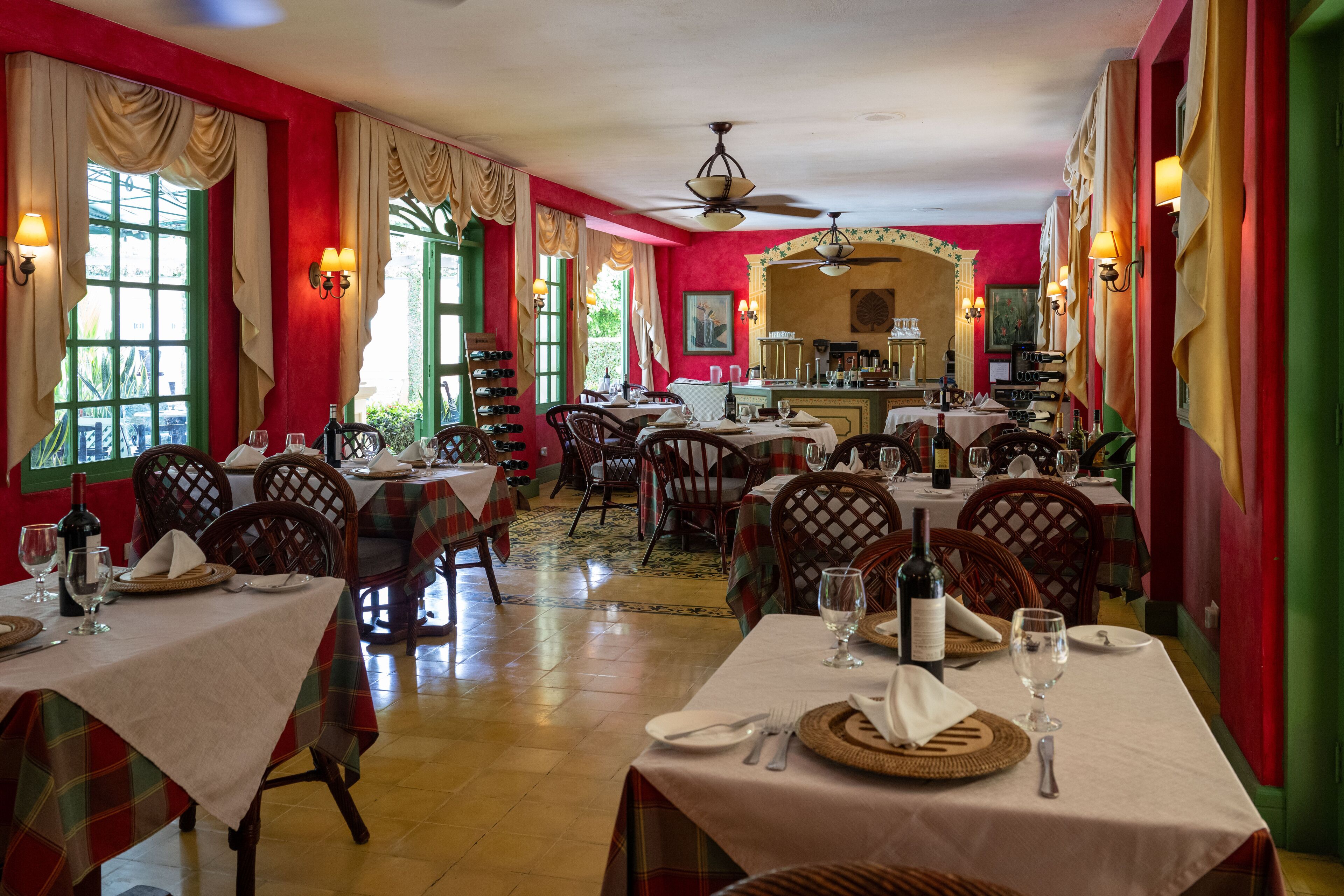 A restaurant with multiple dining tables, chairs, and a bar area.