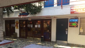 Ein Restaurant mit einem Hinweisschild für den Ausgang, einem Schild für die Lounge und einem Schild für die Bar.