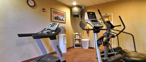 A hotel fitness room with a treadmill, elliptical, and stationary bike.