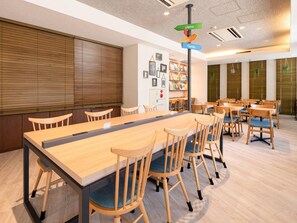 A conference room with a long table and multiple chairs, a bookshelf with framed pictures, and a signpost with directional arrows. - Comfort Hotel Tokyo Kiyosumi Shirakawa (Tokyo)