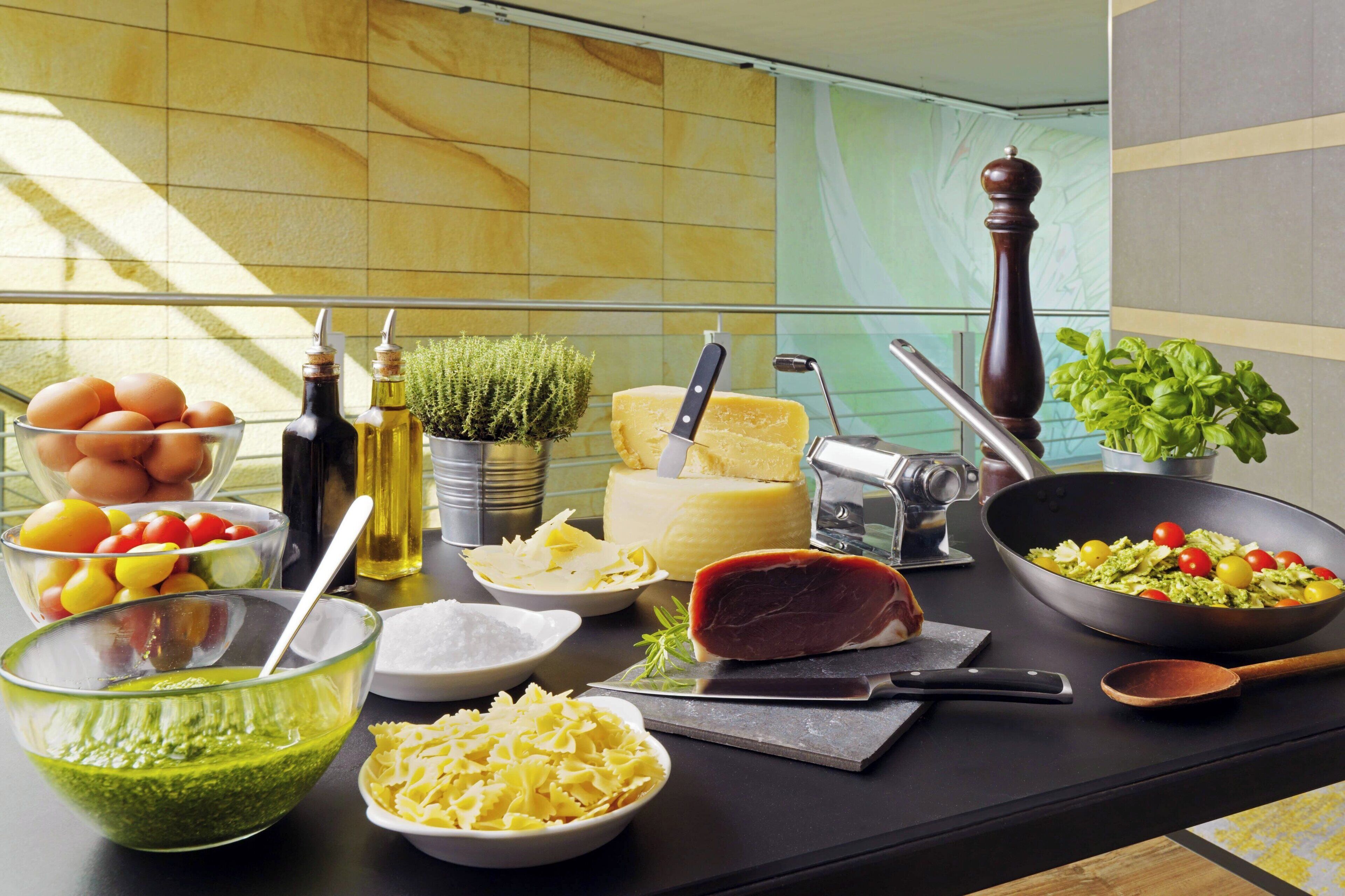 A kitchen counter with various food items and kitchen utensils.