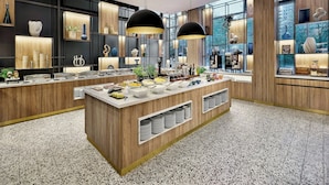 Een moderne keuken met een centraal eiland, houten keukenkastjes en grote ramen.