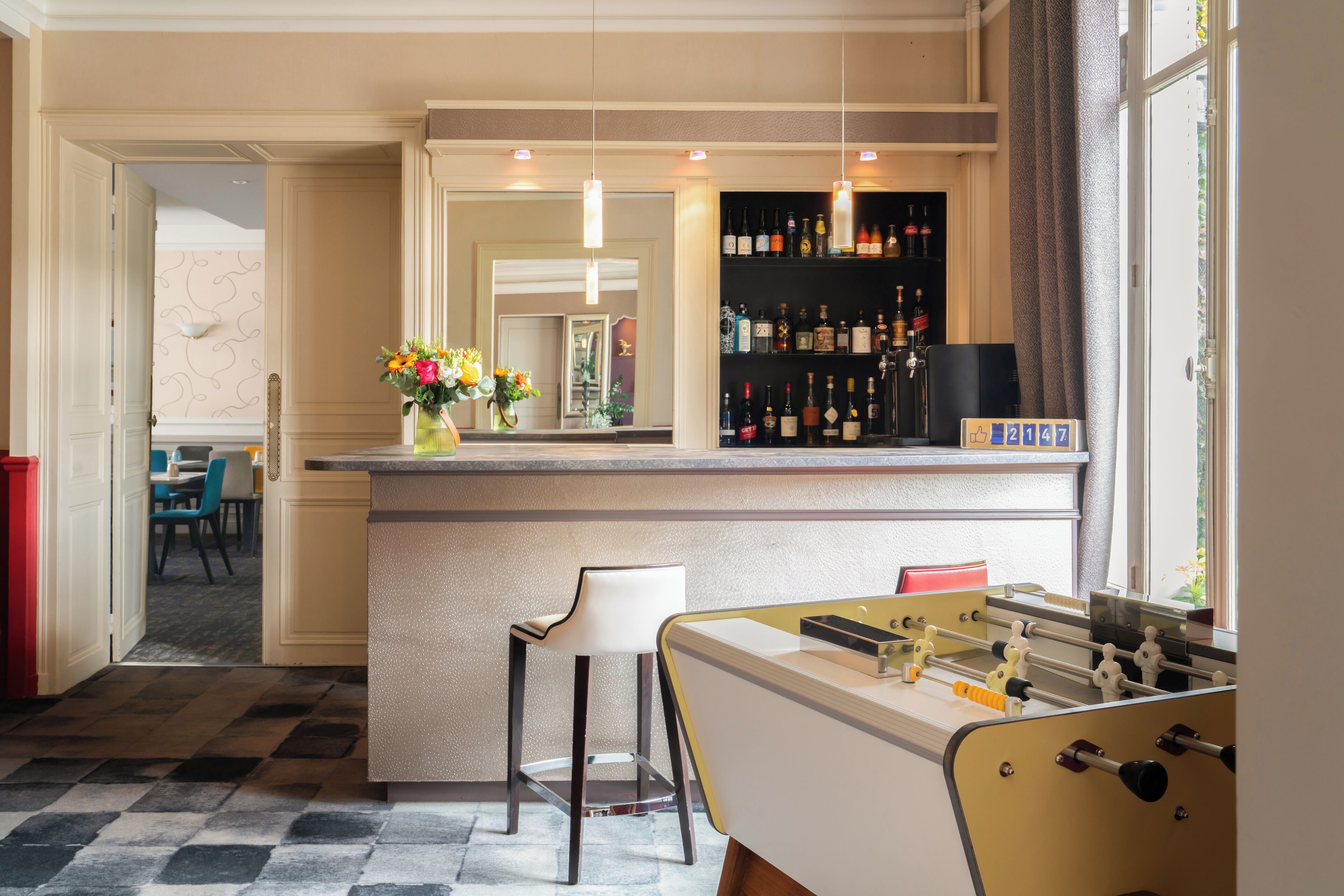 Eine Bar mit einer Kicker-Tisch, einer Theke und einem Weinschränkchen.
