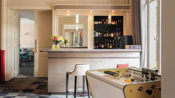 Eine Bar mit einer Kicker-Tisch, einer Theke und einem Weinschränkchen.