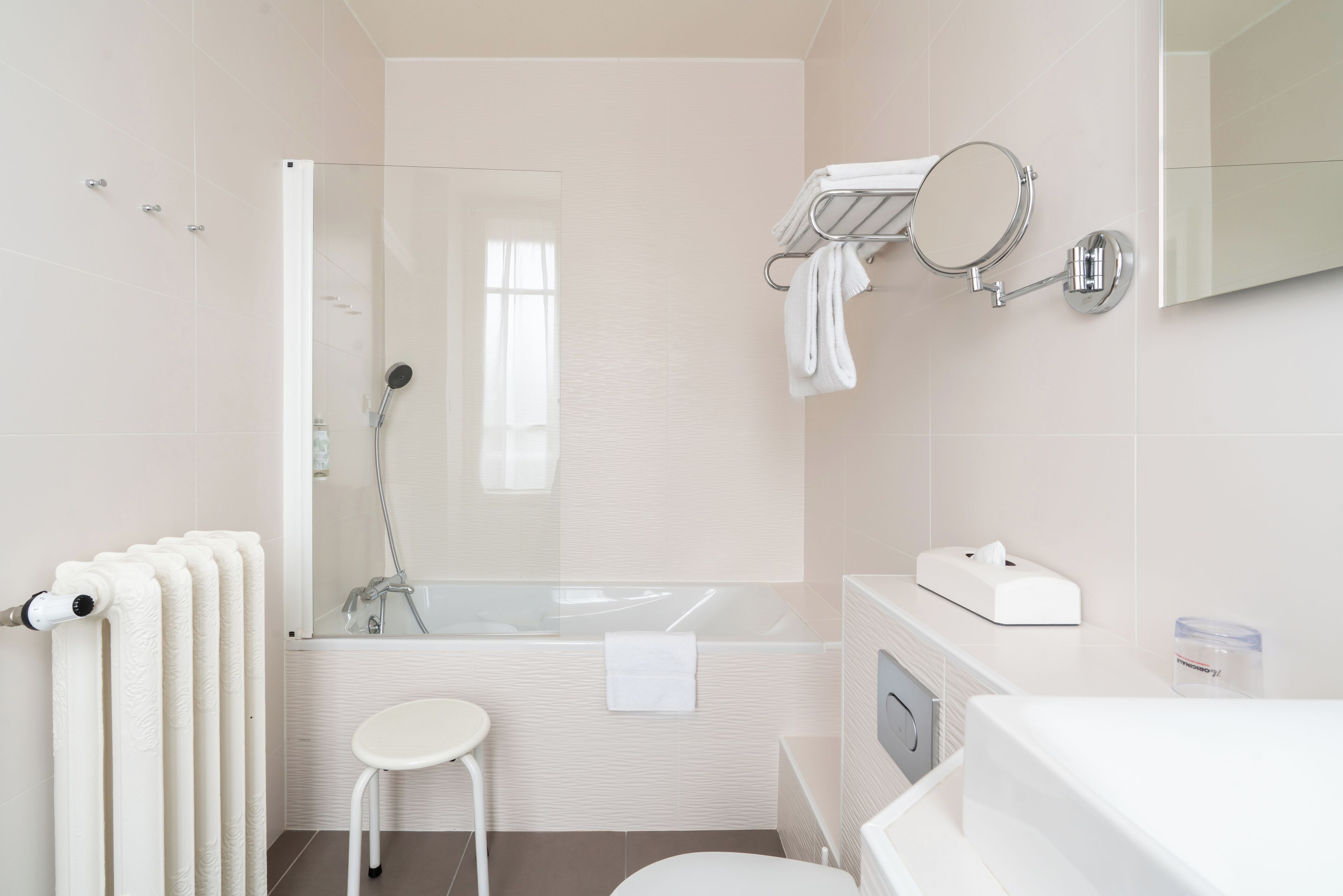 A modern bathroom with a glass shower enclosure, a bathtub, a toilet, and a sink.