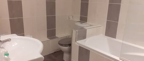 A bathroom with a white sink, toilet, and bathtub.