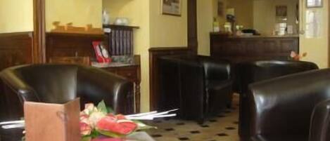 A hotel lobby with leather seating, a reception desk, and a check-in counter.