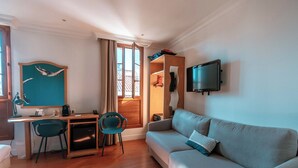 Un salon moderne comprenant un canapé, un bureau, une chaise et un téléviseur.