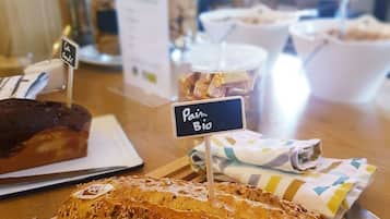 Mostrador de panadería con diversos panes y pasteles, incluyendo un pan marcado como 'Pain Bio'.