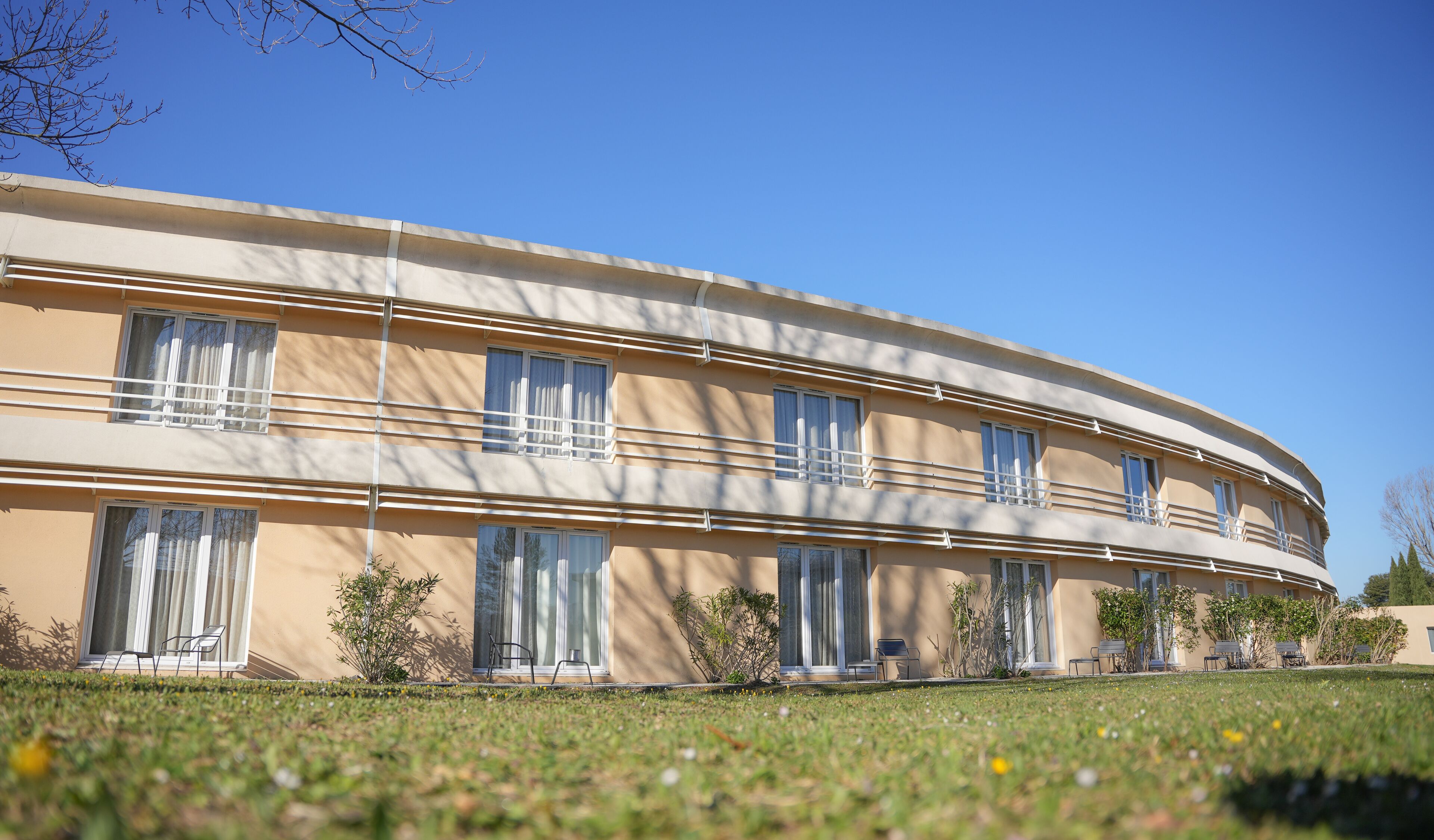 En moderne bygning med buede former, flere balkoner og store vinduer.