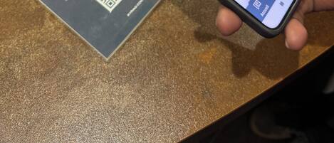 Un teléfono inteligente mostrando un sitio web de reservas de hotel con un código QR y texto en francés.