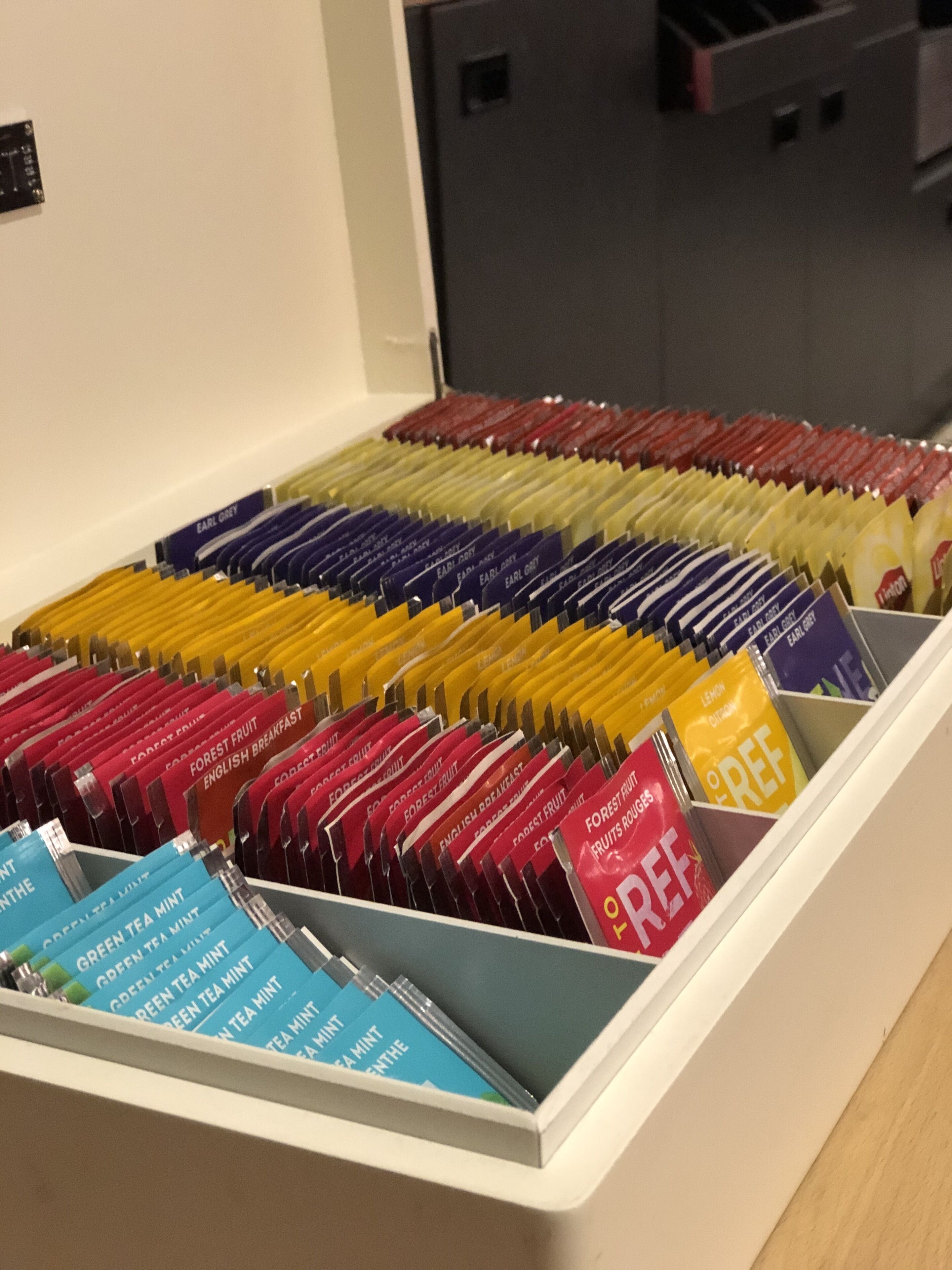A drawer filled with neatly organized tea bags in various colors.