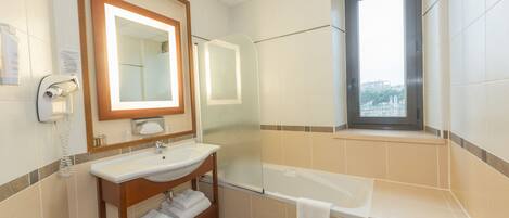A bathroom with a sink, mirror, and bathtub.