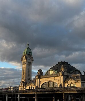 A historic building with a clock tower and a dome, featuring intricate architectural details and a prominent entrance.