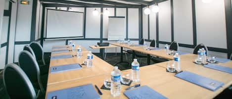 A conference room with a long table, chairs, water bottles, and nameplates.
