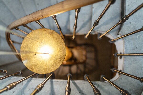 A spiral staircase with a central light fixture.