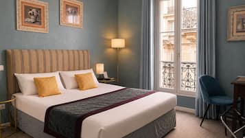 A hotel room with a large bed, two bedside lamps, a chair, and a window with a view of the outside.