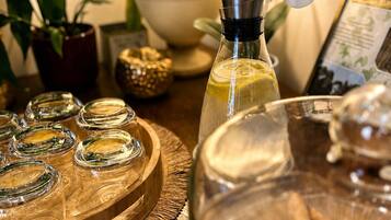 A table with a glass bottle, a wooden tray with glass containers, a decorative orchid, and a framed certificate.
