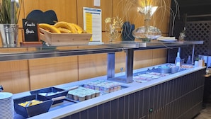 A buffet setup with various food items and a sign indicating 'Fruits frais'. - Hôtel Grand Confort Le Moulin Rouge (Terrasson-la-Villedieu)
